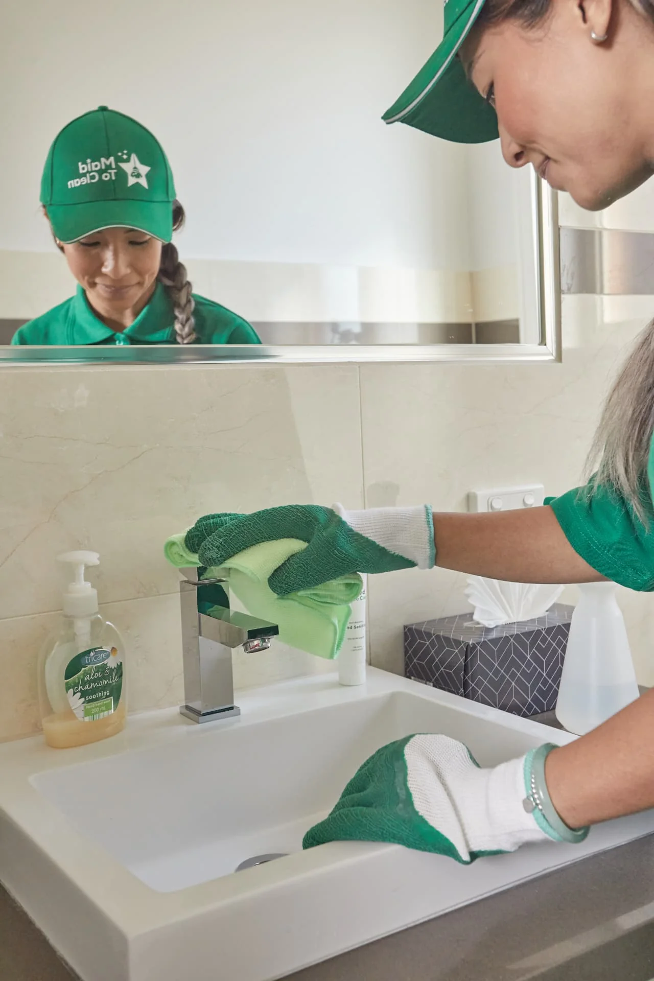 Maid to Clean cleaner wiping a bathroom vanity and tap