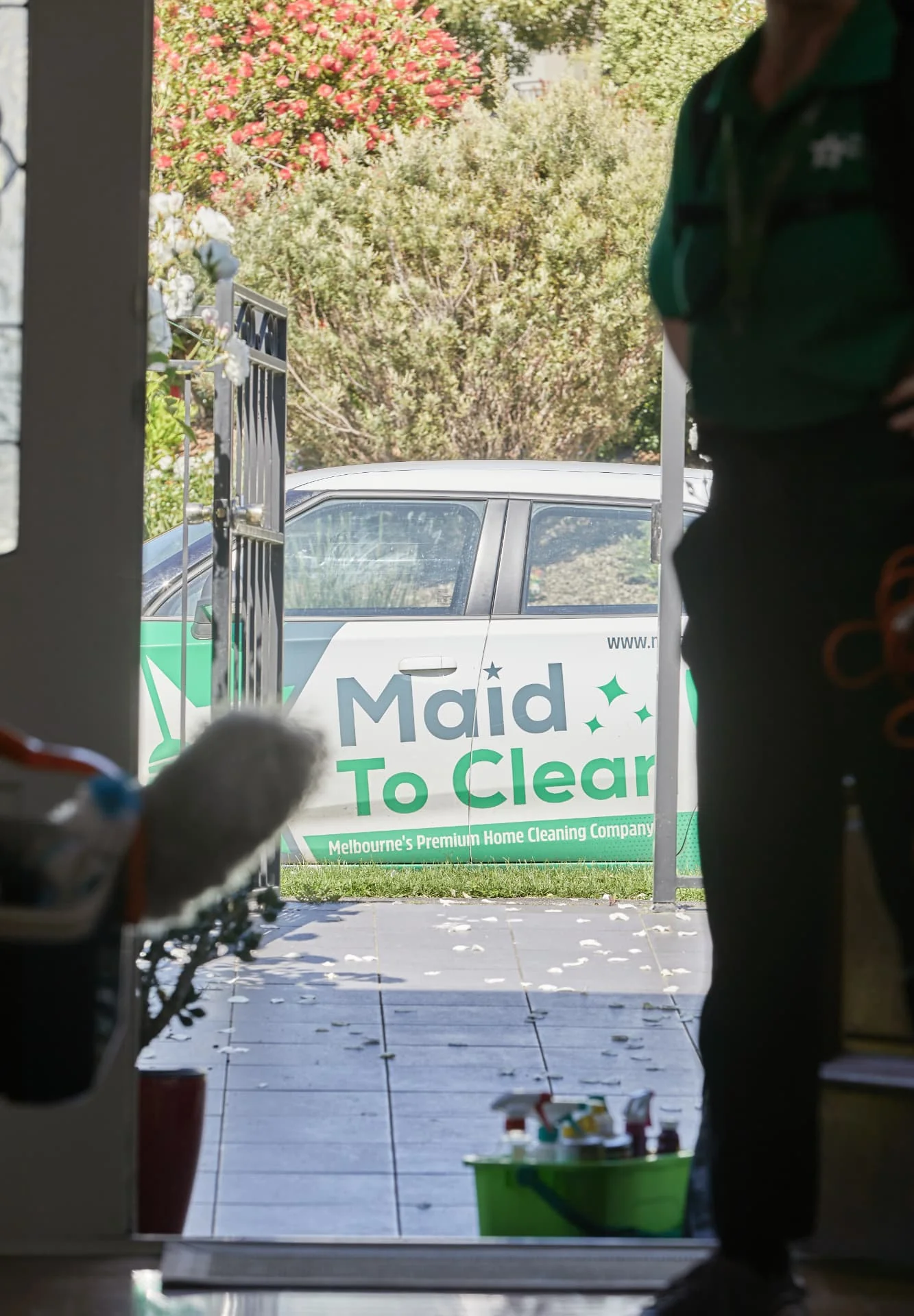 View through a front door to the branded Maid to Clean car parked outside a Melbourne home